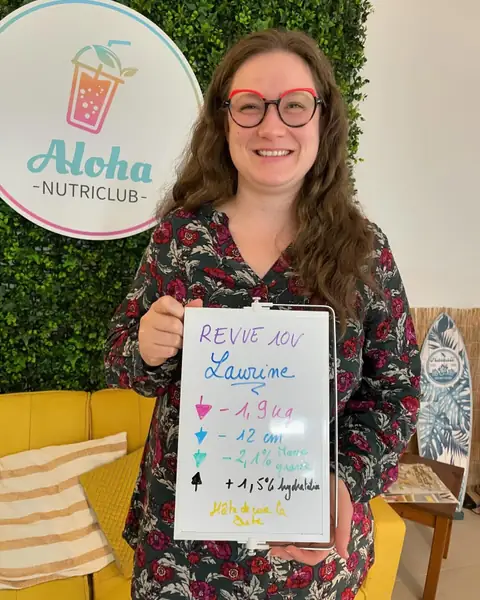 Une membre brandit une ardoise blanche où figure son bilan, au club