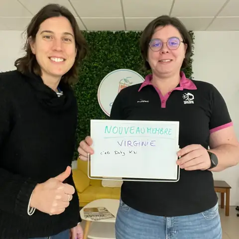 Au club, une membre ravie brandit son ardoise de bilan