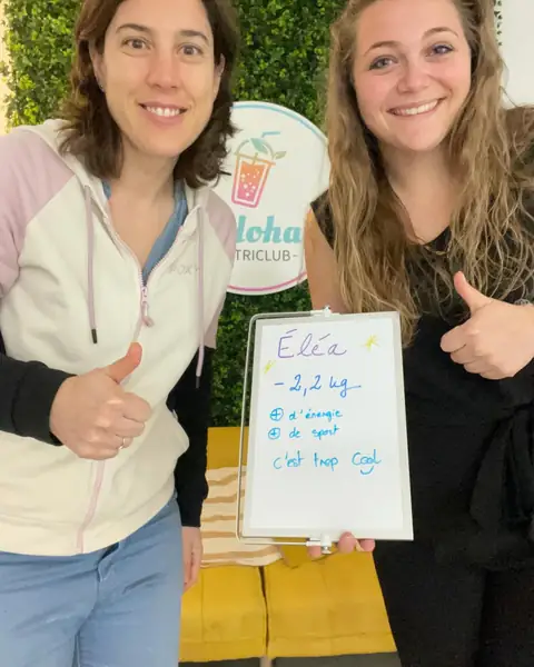 Une membre brandit une ardoise blanche où figure son bilan, au club